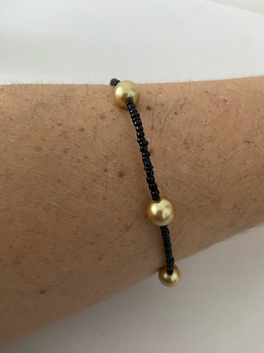 beige faux pearl and black bead bracelet